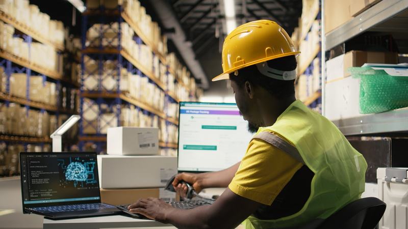 An operator scanning cargo with a tracking screen